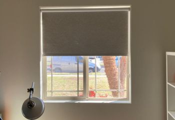 Home office window in Sunnyvale with blackout roller shade partially open, letting in natural light while still providing privacy.