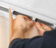 A male installing vertical blinds