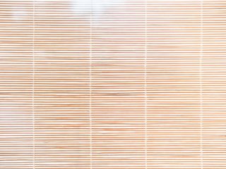 Woven Wood Blinds | Sunnyvale Blinds & Shade CA Living room with large window adorned with woven wood blinds, creating a cozy and natural atmosphere.